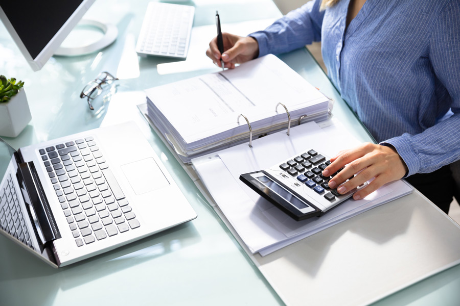 tax-preparer Photo of a Professional Tax Preparer sitting at a desk with a laptop computer and a calculator